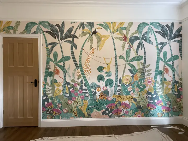 Botanical wallpaper mural installed across a bedroom wall with white skirting and a timber door