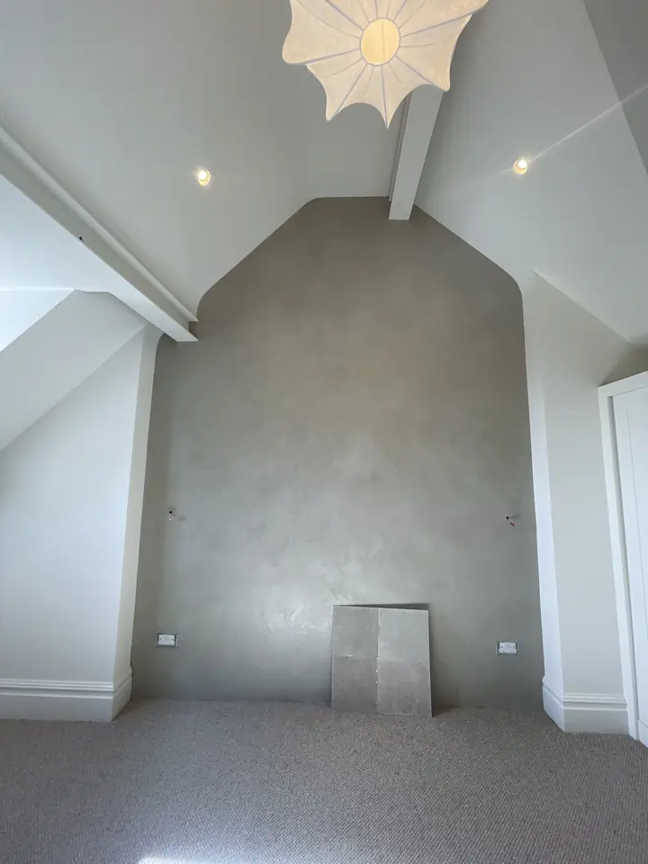 Tall polished plaster feature wall with an arched recess and recessed ceiling lights