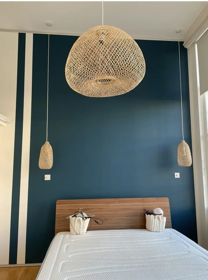 Teal painted bedroom feature wall with crisp edges and soft natural light