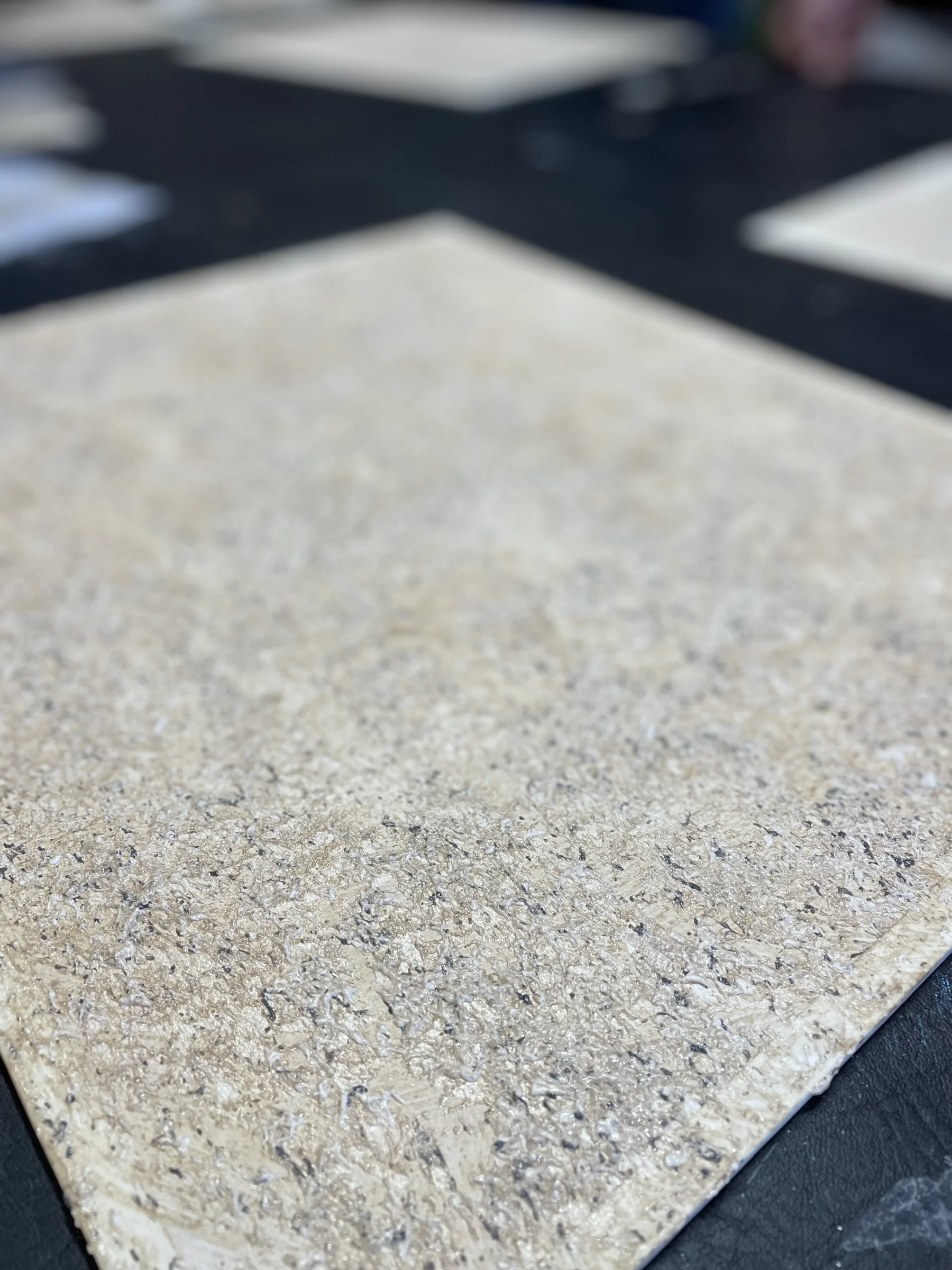 Close-up of a textured finish sample with a fine speckled surface