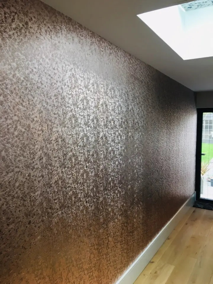 Textured wallpaper installed in a hallway with detailed woodwork