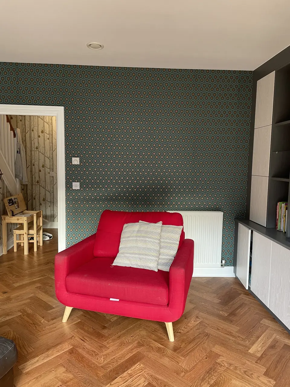 Muswell Hill entrance stairwell hung with bold Hicks Hexagon wallpaper across walls and stair rise detail view