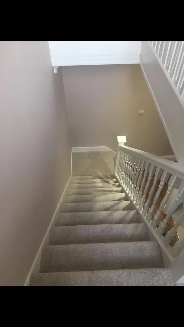 Crouch End period stairwell with restored white balusters, stained wooden treads and warm white walls detail view