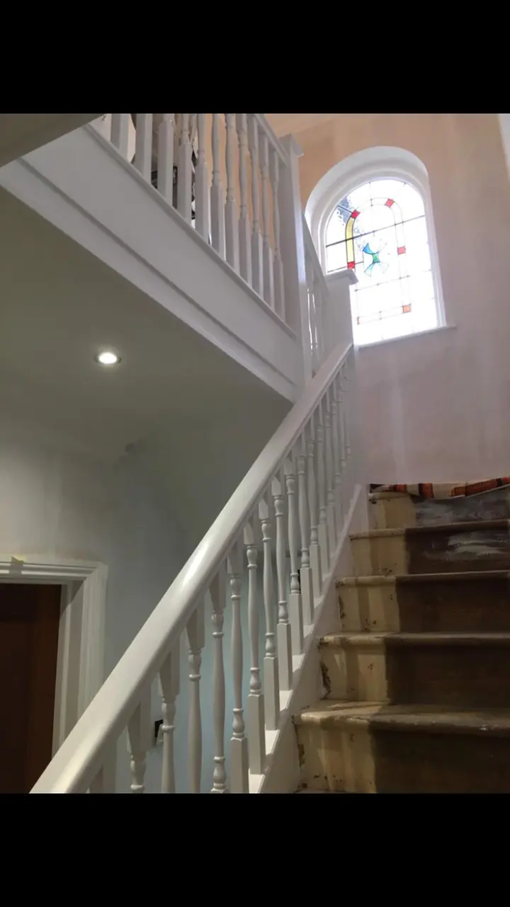 Crouch End period stairwell with restored white balusters, stained wooden treads and warm white walls in-progress view