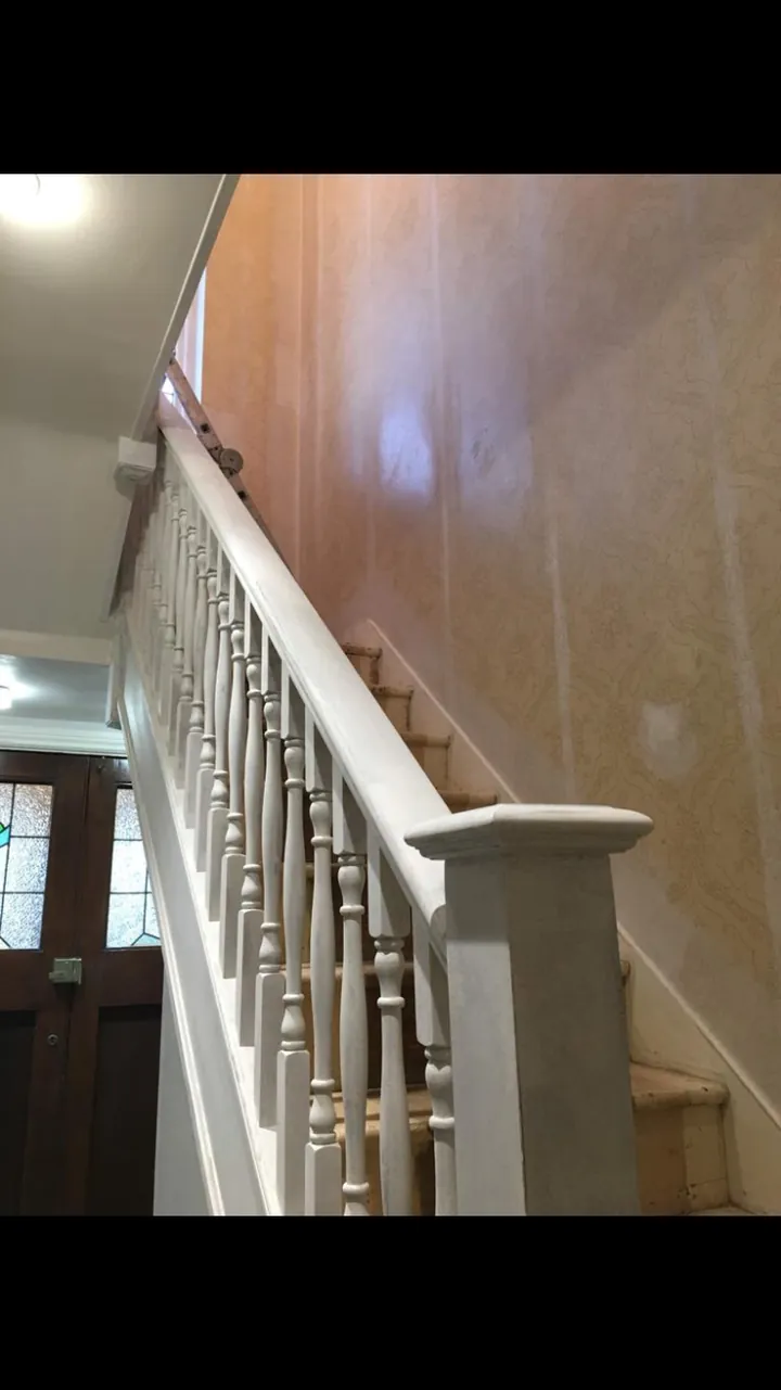 Crouch End period stairwell with restored white balusters, stained wooden treads and warm white walls finished result