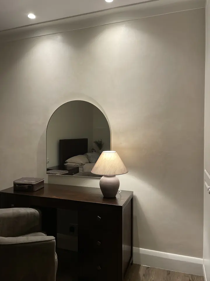 Arched niche with warm decorative plaster and soft recessed lighting